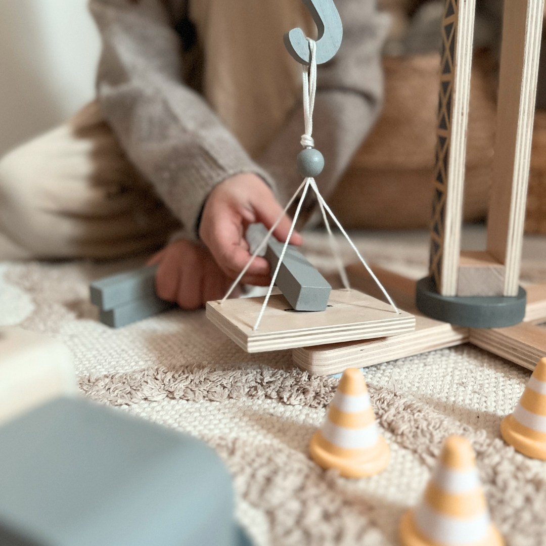 Byggeplads i træ med stor mobilkran og køretøjer, tårnkran