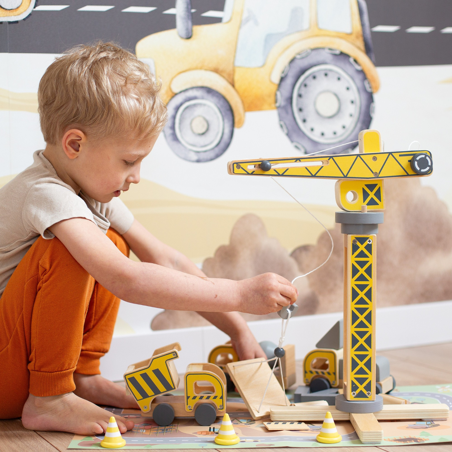 Byggeplads i træ med stor mobilkran og køretøjer, tårnkran