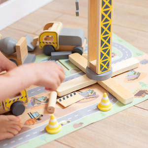 Byggeplads i træ med stor mobilkran og køretøjer, tårnkran