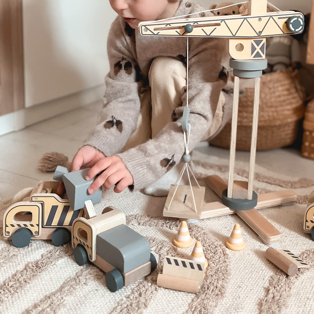 Byggeplads i træ med stor mobilkran og køretøjer, tårnkran