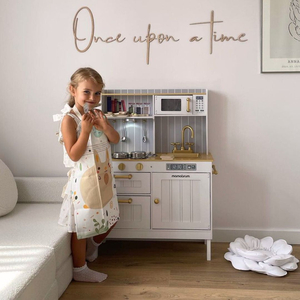 Hvidt køkken i træ med tilbehør og forklæde