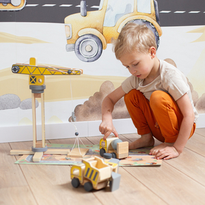 Byggeplads i træ med stor mobilkran og køretøjer, tårnkran